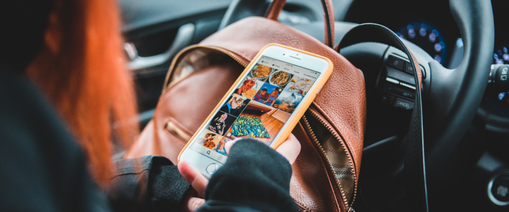 girl in car on phone with screen showing a social media platform